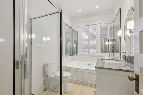 a bathroom with a granite countertop sink a toilet and shower