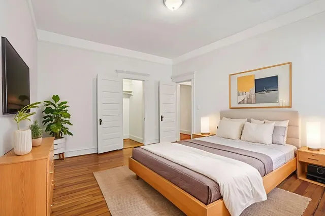 a bedroom with a bed and a potted plant