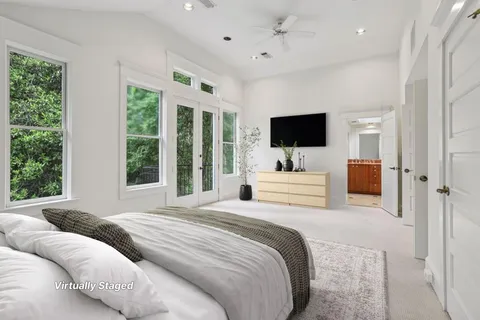 a bedroom with a bed window and a flat screen tv