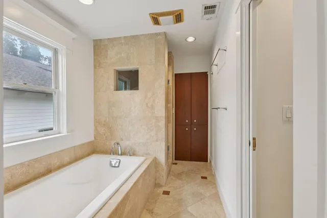 a bathroom with a tub sink and mirror