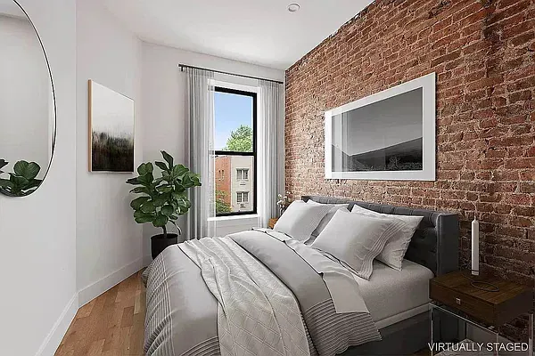 a bedroom with a bed and a potted plant