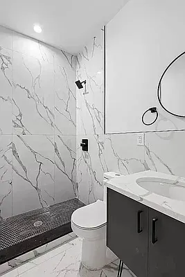 a bathroom with a sink toilet vanity and shower