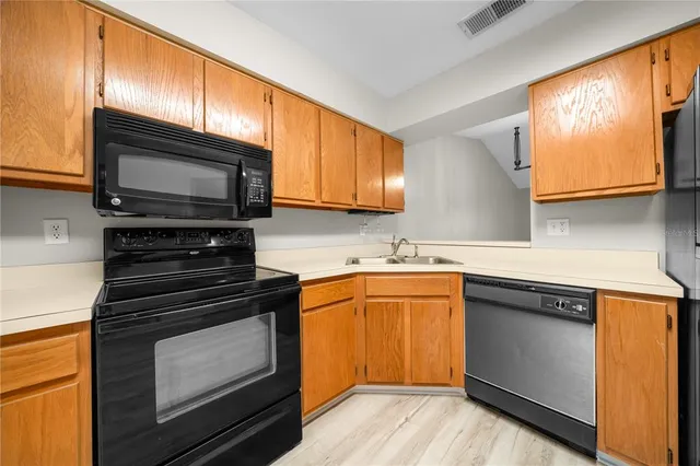 a kitchen with stainless steel appliances granite countertop a stove microwave and sink