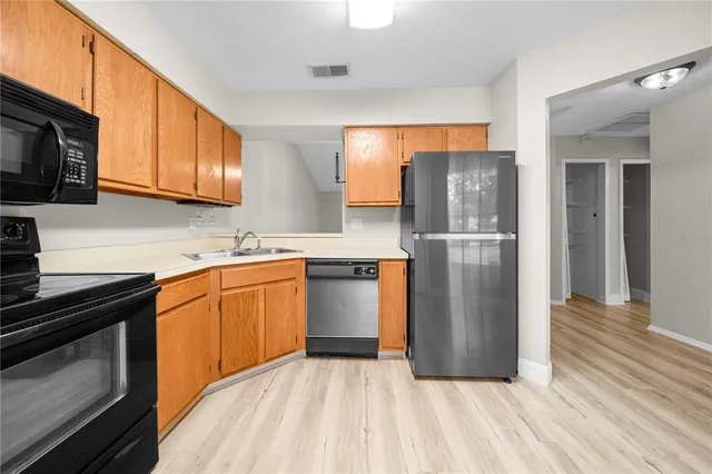 a kitchen with stainless steel appliances granite countertop a refrigerator stove top oven and sink