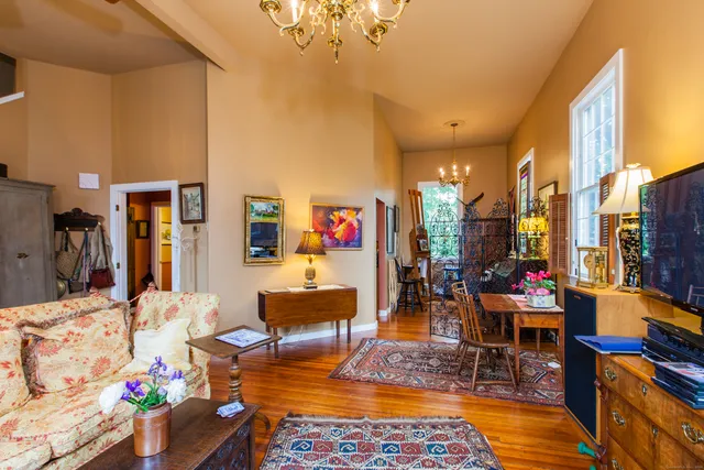 a living room with furniture and a dining table with wooden floor