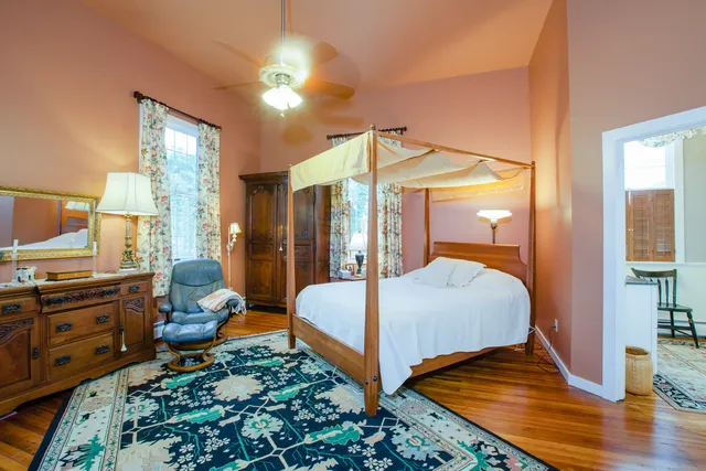 a bedroom with bed and wooden floor