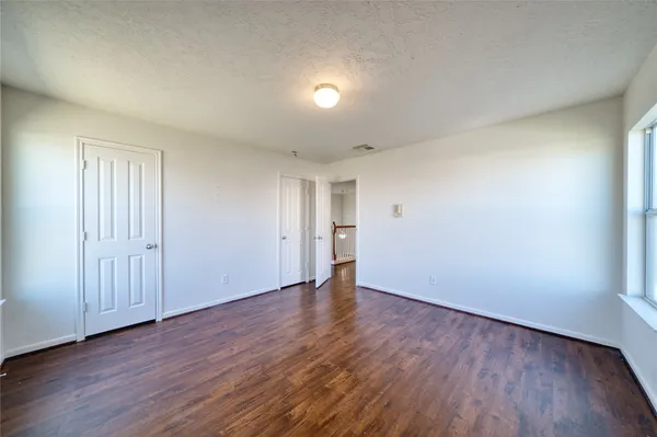 a view of an empty room and wooden floor