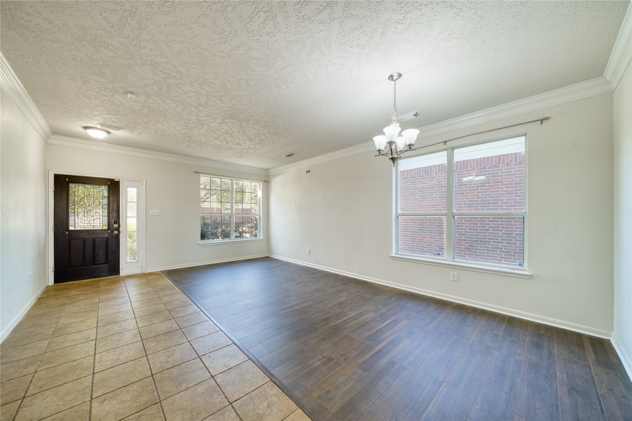 6610 Autumn Sunset Lane Spring, TX 77379 - Photo 7 of 45 an empty room with wooden floor chandelier and windows