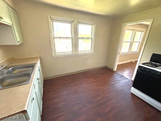 14628 Granger Road Maple Heights, OH 44137 - Photo 24 of 45 Kitchen featuring black gas stove, white cabinets, dark wood-type flooring, and sink