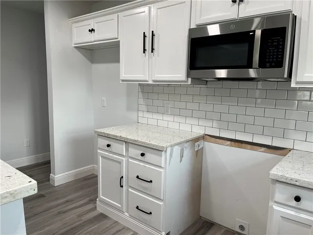 a kitchen with stainless steel appliances a stove microwave and cabinets