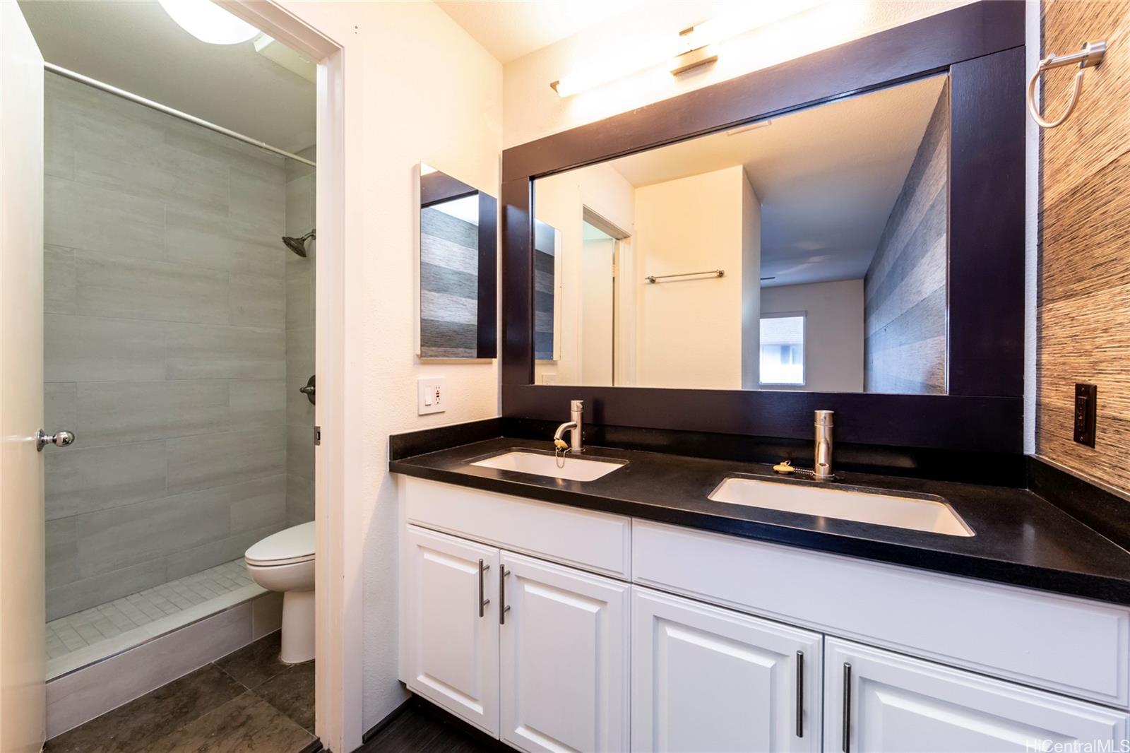 92-1475 Ali'inui Drive, Unit 20B Kapolei, HI 96707 - Photo 13 of 18 a bathroom with a double vanity sink toilet and shower
