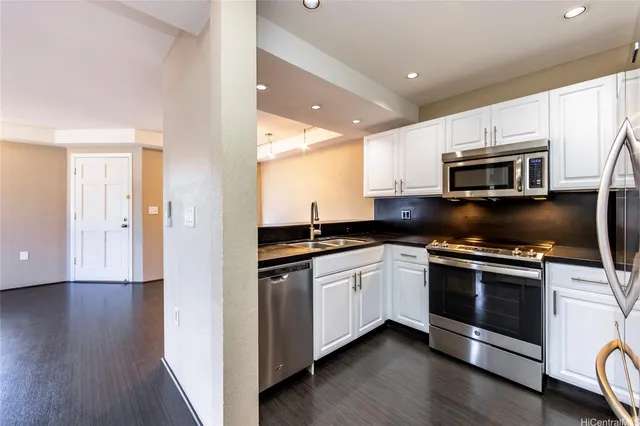 a kitchen with stainless steel appliances granite countertop a stove a sink and a microwave