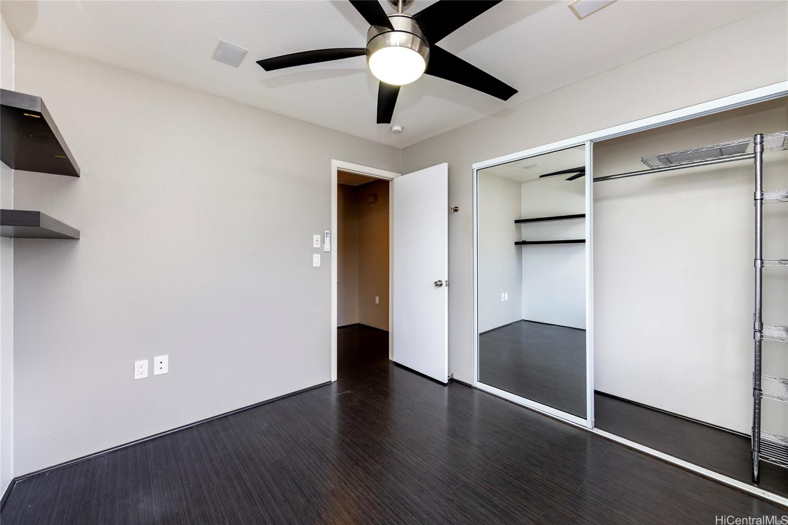 92-1475 Ali'inui Drive, Unit 20B Kapolei, HI 96707 - Photo 9 of 18 an empty room with wooden floor and a ceiling fan