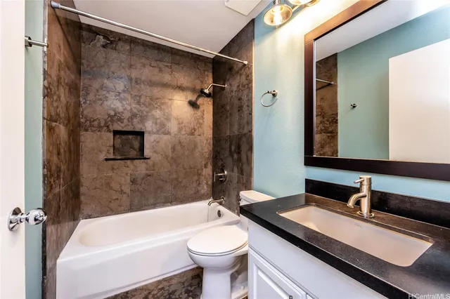 a bathroom with a granite countertop sink toilet and shower