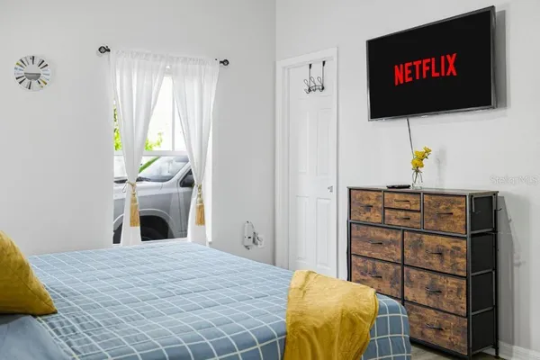 a bedroom with a bed and a flat screen tv