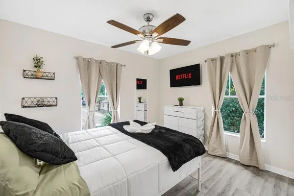 a bedroom with a bed a window and a flat screen tv