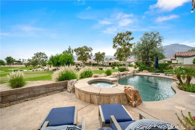 a view of a patio with a table and chairs potted plants and palm trees