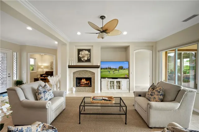 a living room with furniture a fireplace and a floor to ceiling window