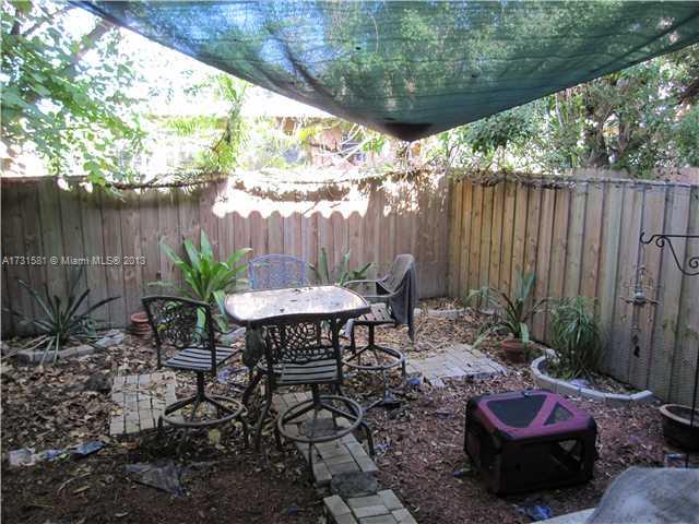 3749 Southwest 27th Lane, Unit 3749 Miami, FL 33134 - Photo 15 of 16 a view of a backyard with table and chairs potted plants and tree