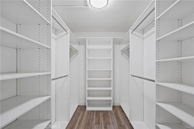 a view of walk in closet with empty racks