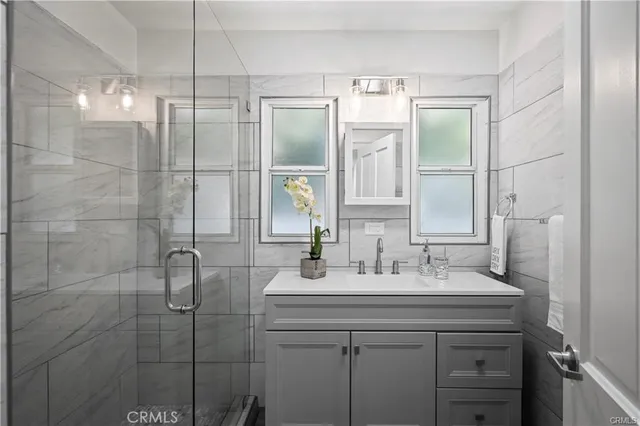 a bathroom with a shower sink and mirror