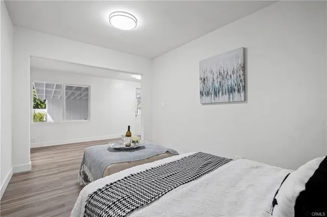 a bedroom with a bed and painting on the wall