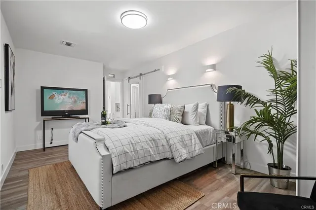 a spacious bedroom with a bed and a flat screen tv