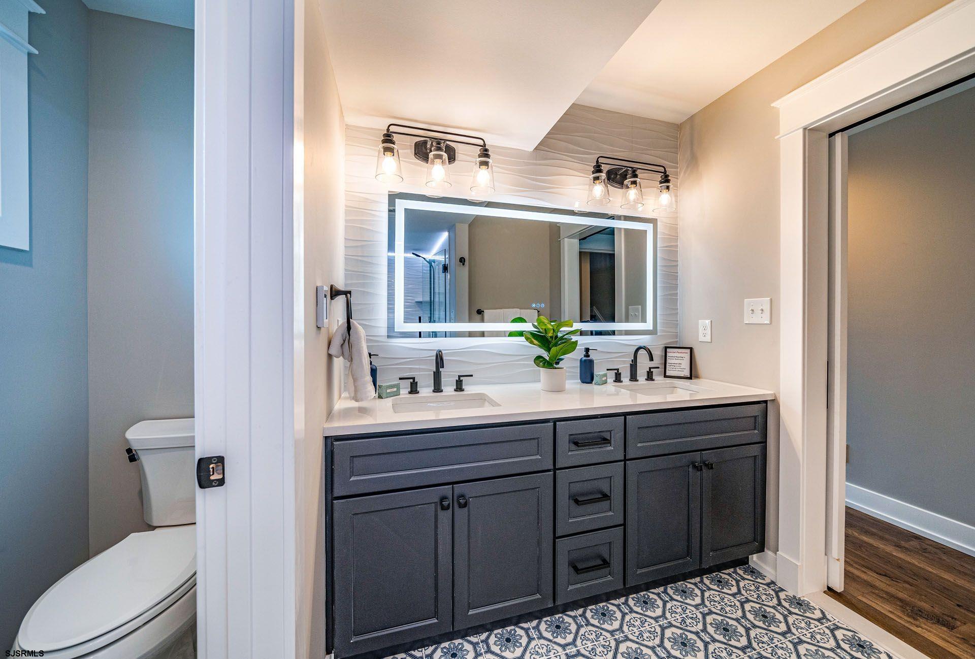 4 Wesley Road Ocean City, NJ 08226 - Photo 30 of 44 a spacious bathroom with a granite countertop toilet sink and mirror