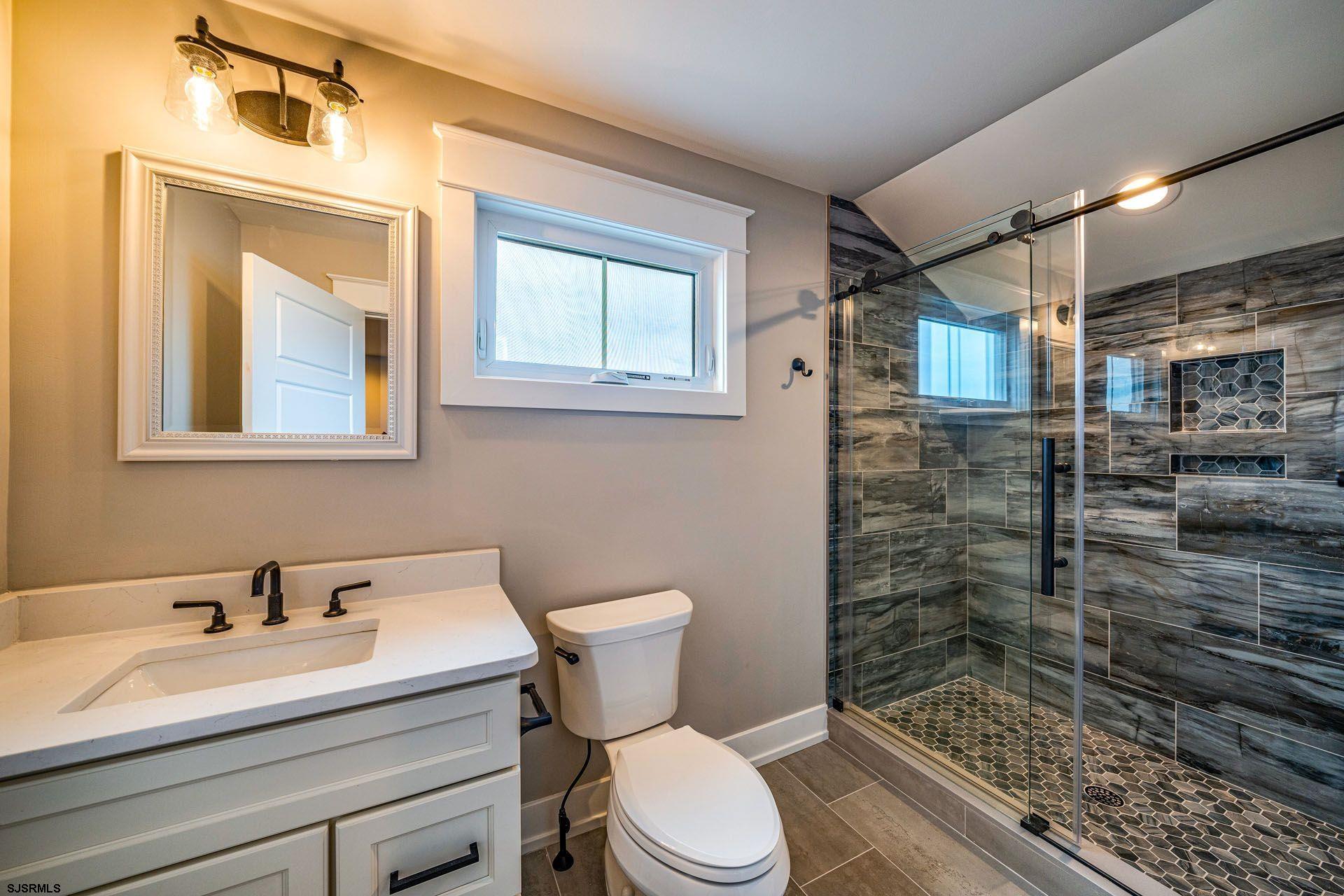 4 Wesley Road Ocean City, NJ 08226 - Photo 10 of 44 a bathroom with a sink a toilet a mirror and shower