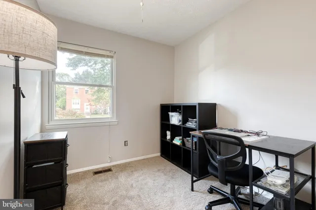 a view of a workspace with furniture and a window