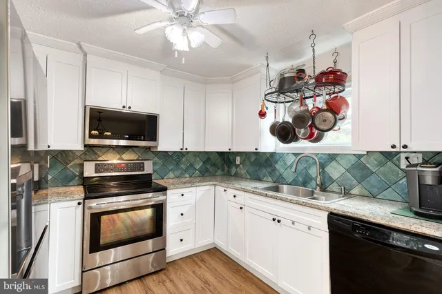 a kitchen with stainless steel appliances white cabinets and a stove