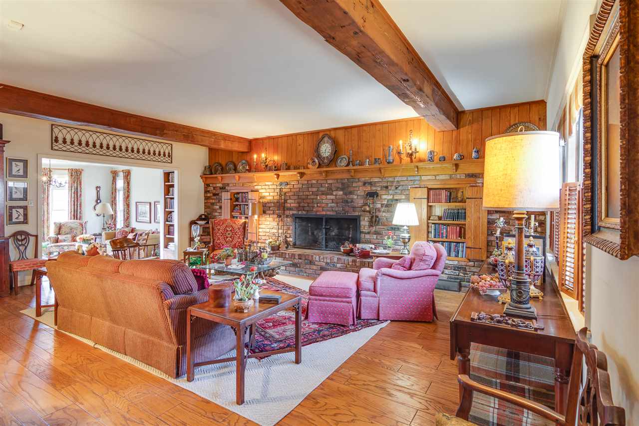 Expansive entertaining space, beginning with the living room with its old beams and hardwood floors.  Beyond is an inviting sunroom.