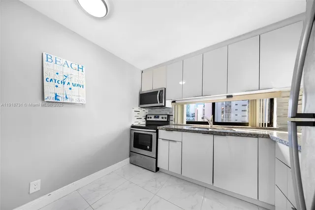 a kitchen with white cabinets and refrigerator