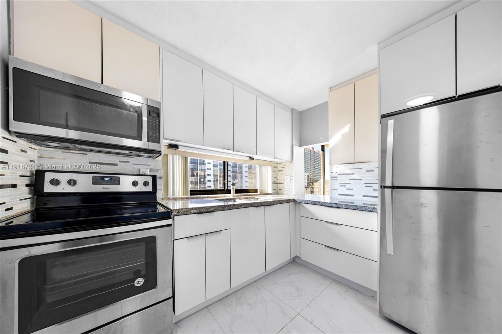 17011 North Bay Road, Unit 718 Sunny Isles Beach, FL 33160 - Photo 17 of 24 a kitchen with cabinets stainless steel appliances and a counter space