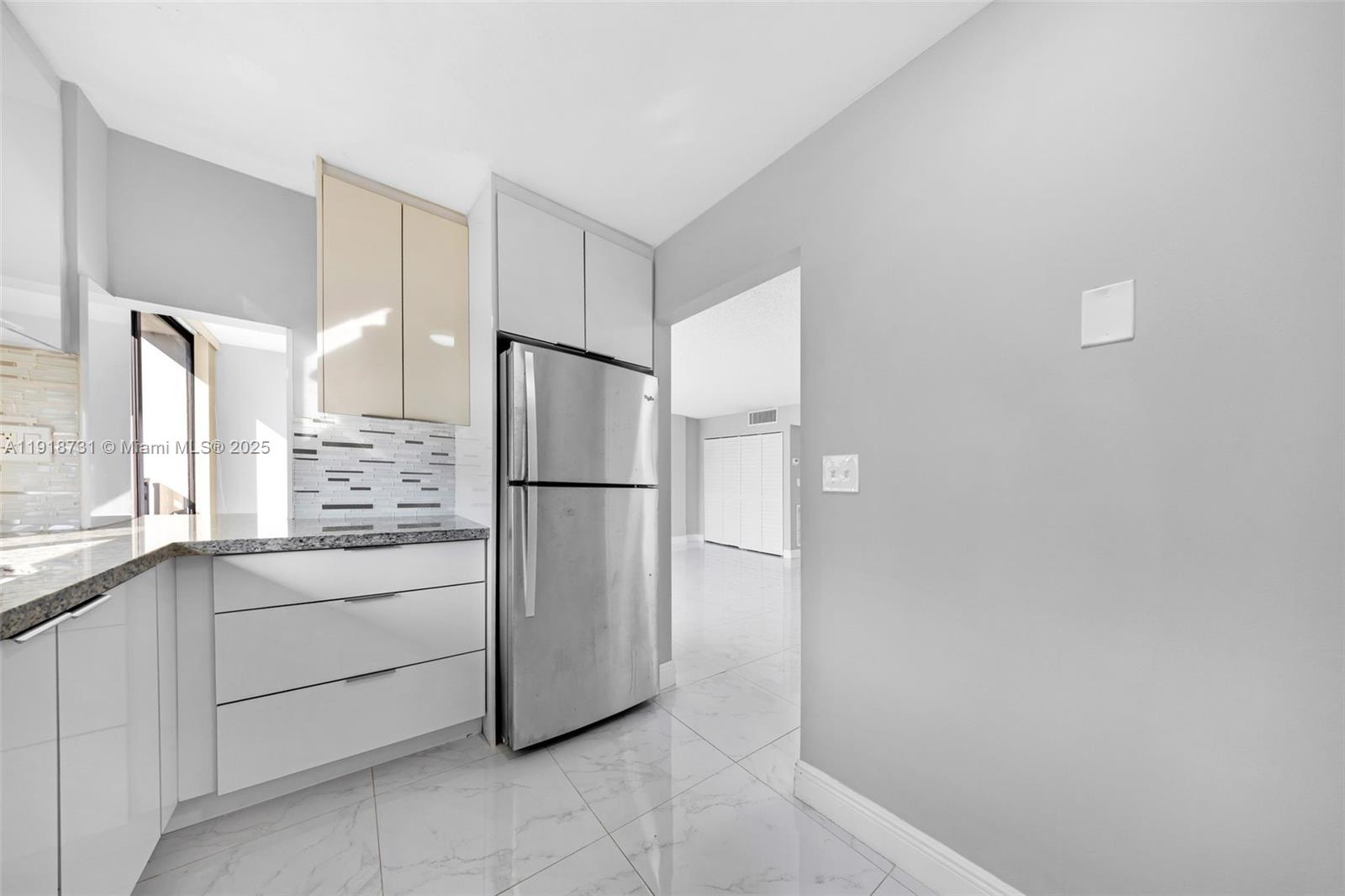 17011 North Bay Road, Unit 718 Sunny Isles Beach, FL 33160 - Photo 18 of 24 a kitchen with white cabinets and refrigerator