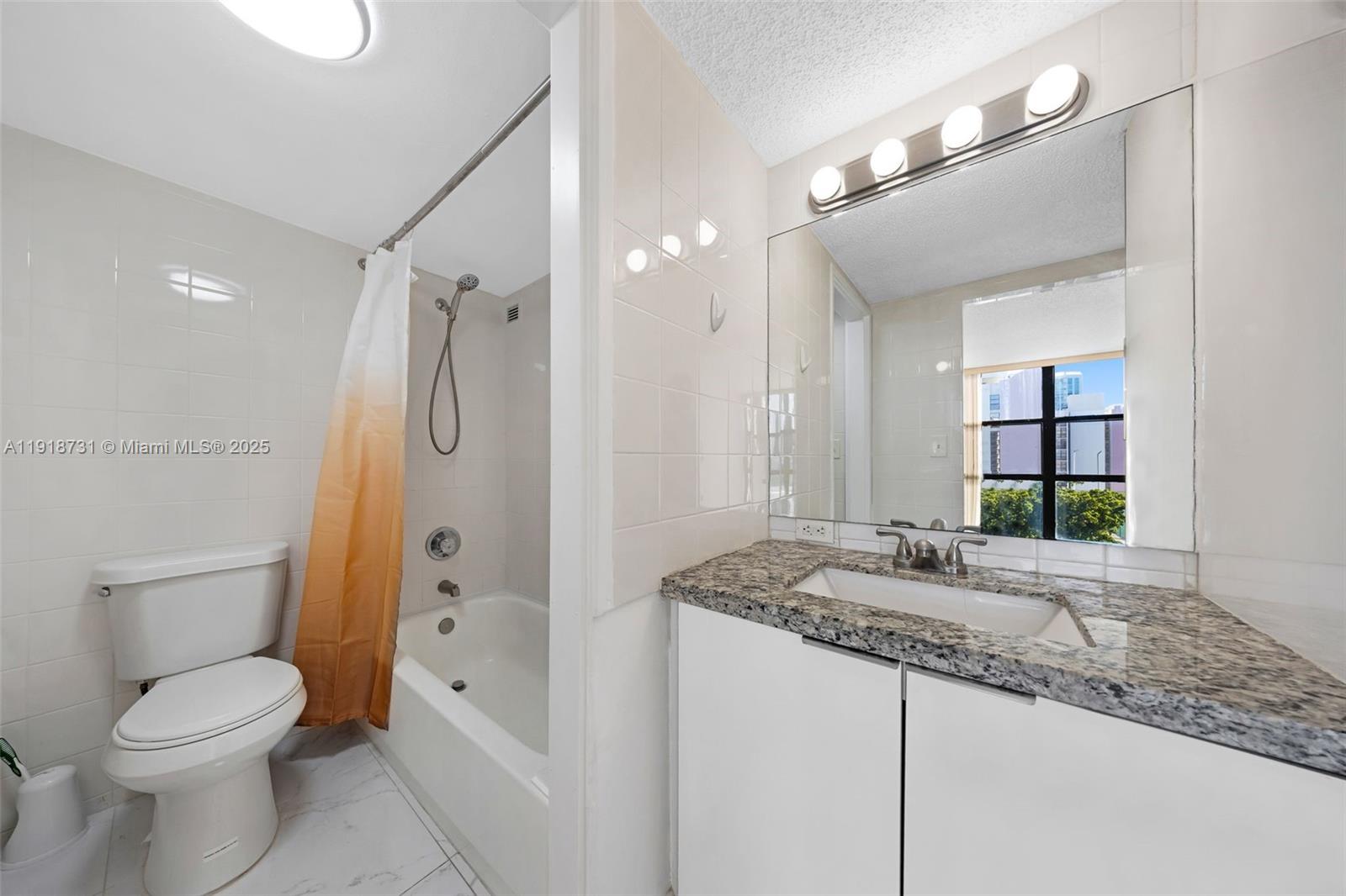 17011 North Bay Road, Unit 718 Sunny Isles Beach, FL 33160 - Photo 24 of 24 a bathroom with a granite countertop sink toilet and shower