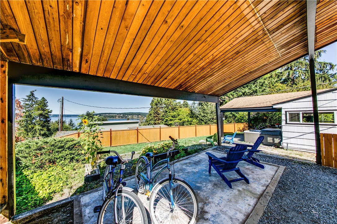 4401 Sunset Beach Road West University Place, WA 98466 - Photo 11 of 40 a view of a patio with table and chairs under an umbrella with a patio
