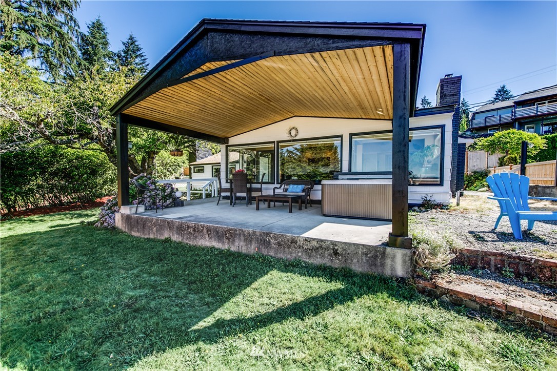 4401 Sunset Beach Road West University Place, WA 98466 - Photo 12 of 40 a porch with outdoor seating and a garden