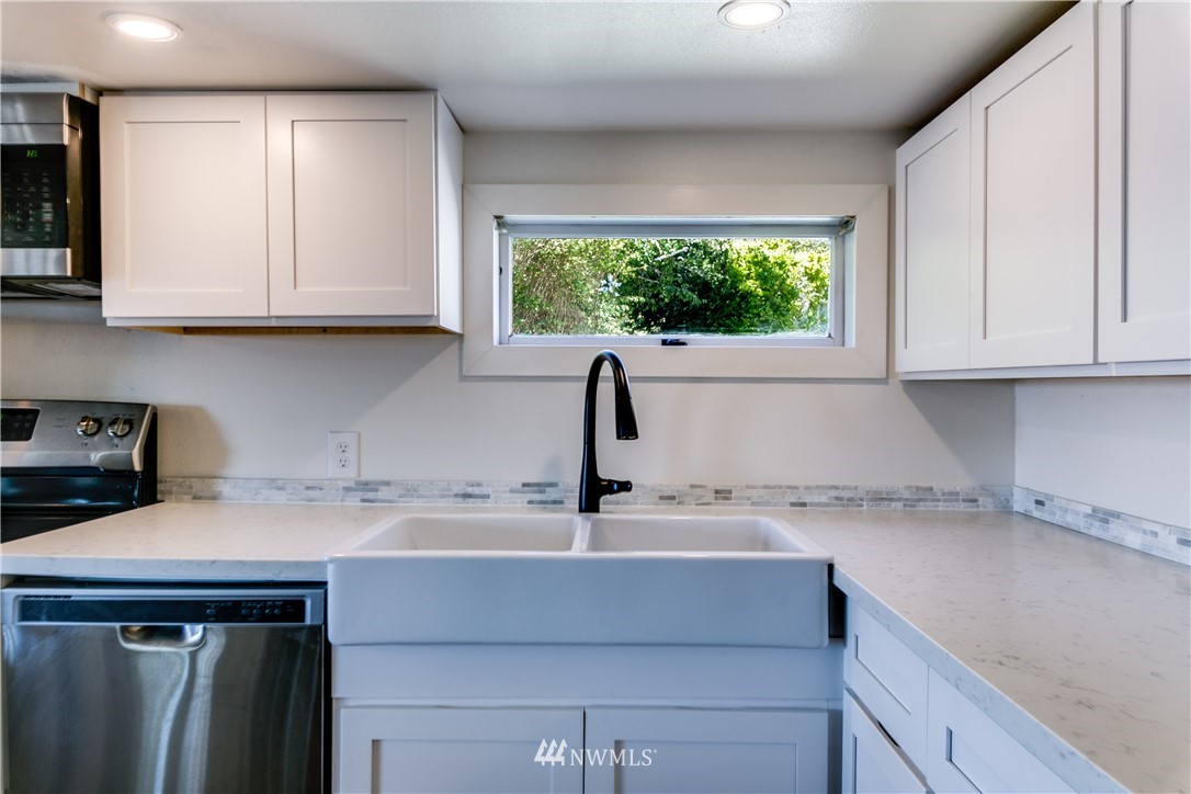 4401 Sunset Beach Road West University Place, WA 98466 - Photo 19 of 40 a kitchen with a sink cabinets and window