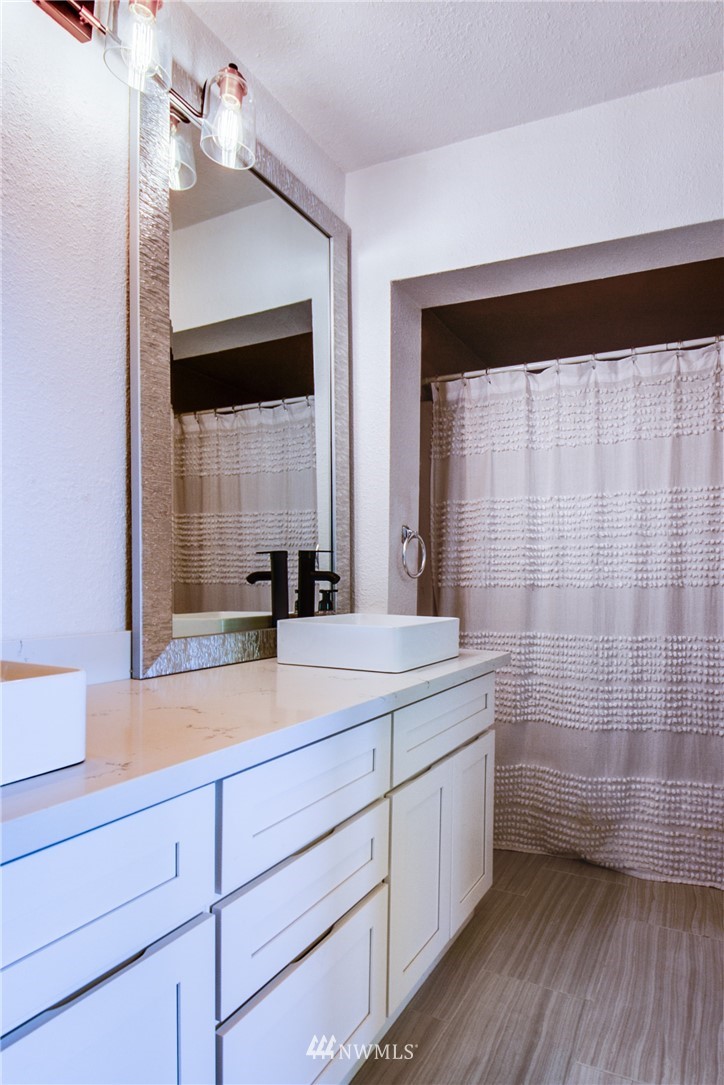 4401 Sunset Beach Road West University Place, WA 98466 - Photo 24 of 40 a bathroom with a sink a mirror and a shower