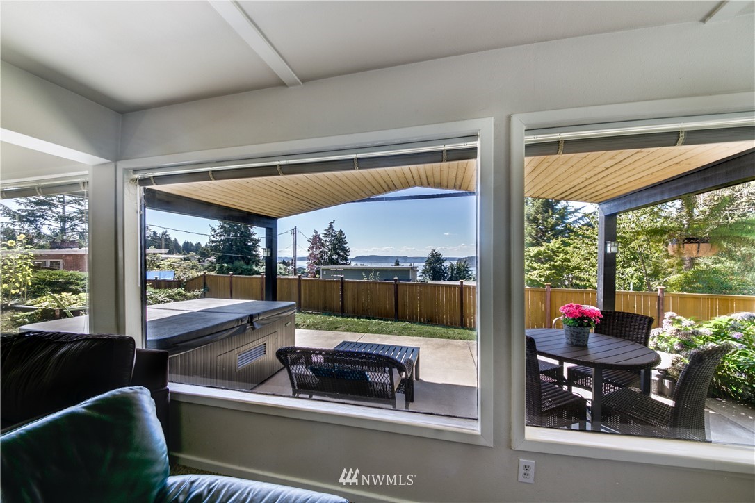4401 Sunset Beach Road West University Place, WA 98466 - Photo 4 of 40 a living room filled with furniture and a floor to ceiling window