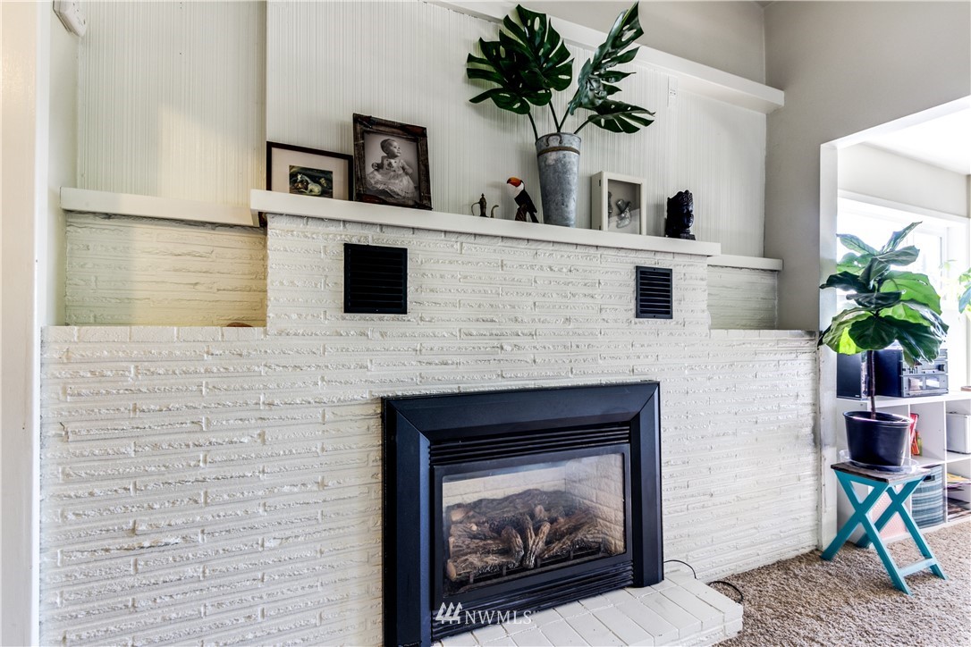4401 Sunset Beach Road West University Place, WA 98466 - Photo 7 of 40 a living room with a fireplace furniture a potted plant and a fireplace