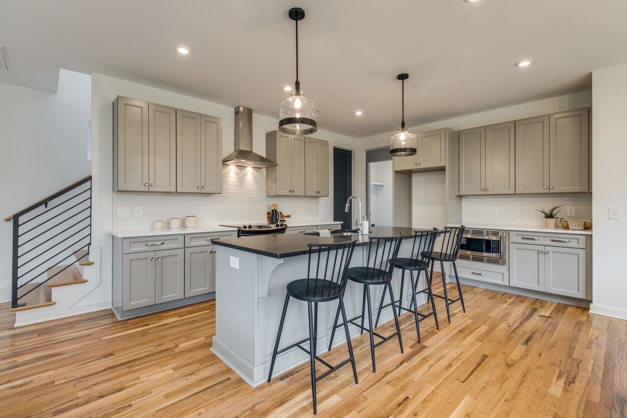 1005 B Mitchell Road Nashville, TN 37206 - Photo 5 of 25 a kitchen with granite countertop wooden floors white cabinets and stainless steel appliances