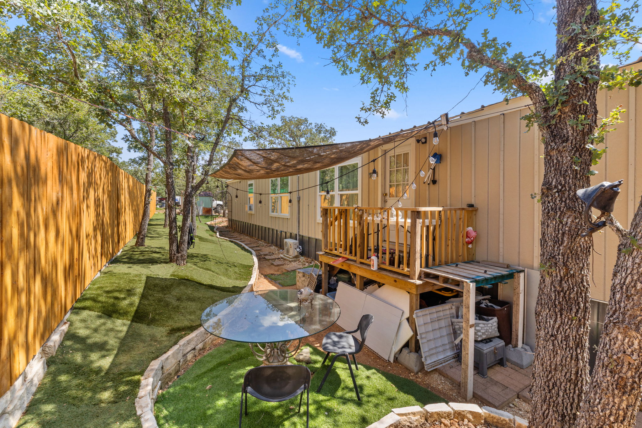 215 Sayers Road Bastrop, TX 78602 - Photo 20 of 26 A private yard with a wooden fence and well-maintained artificial turf offers a serene outdoor retreat.