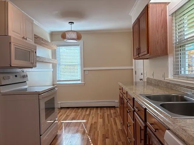 a kitchen with granite countertop a sink a stove and cabinets