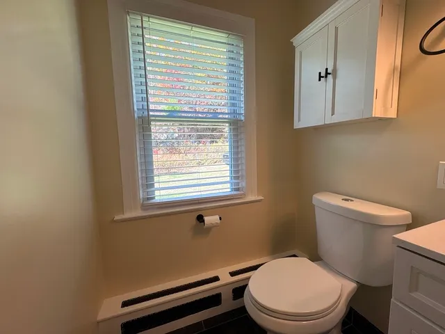 a white toilet sitting next to a window