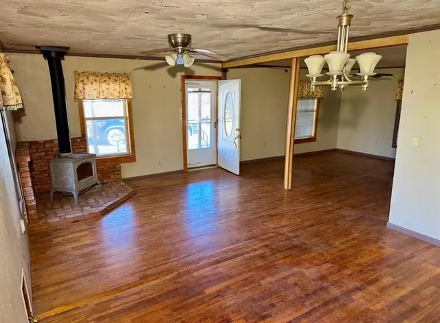 a view of a livingroom with wooden floor and a ceiling fan