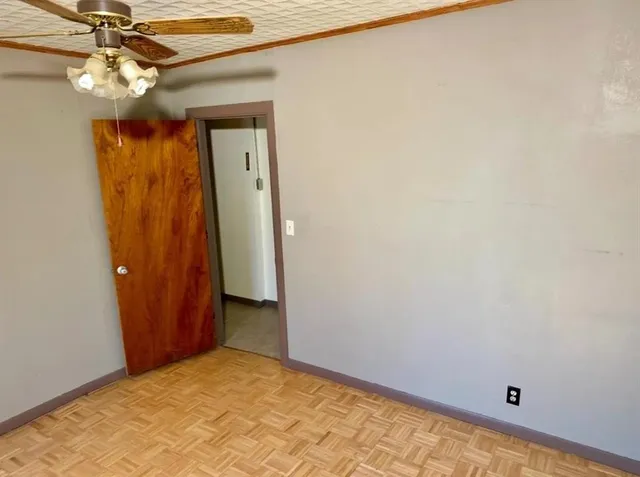a view of a hallway with a chandelier fan and a wooden table
