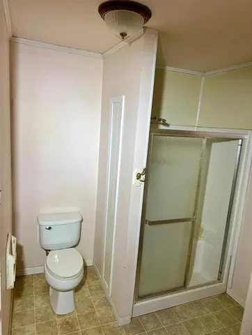a bathroom with a toilet and a shower