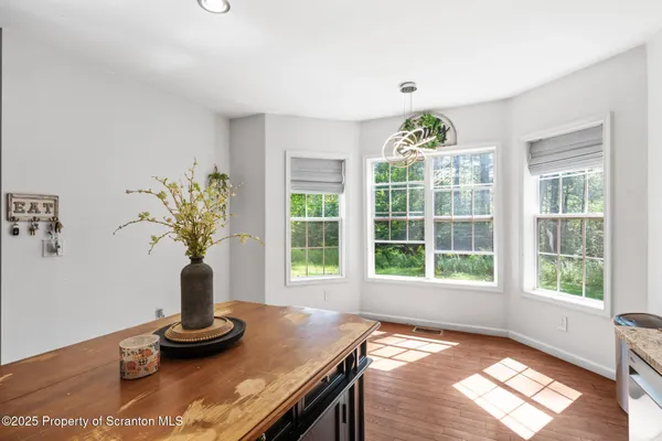 a view of a dining room with chandelier windows and wooden floor
